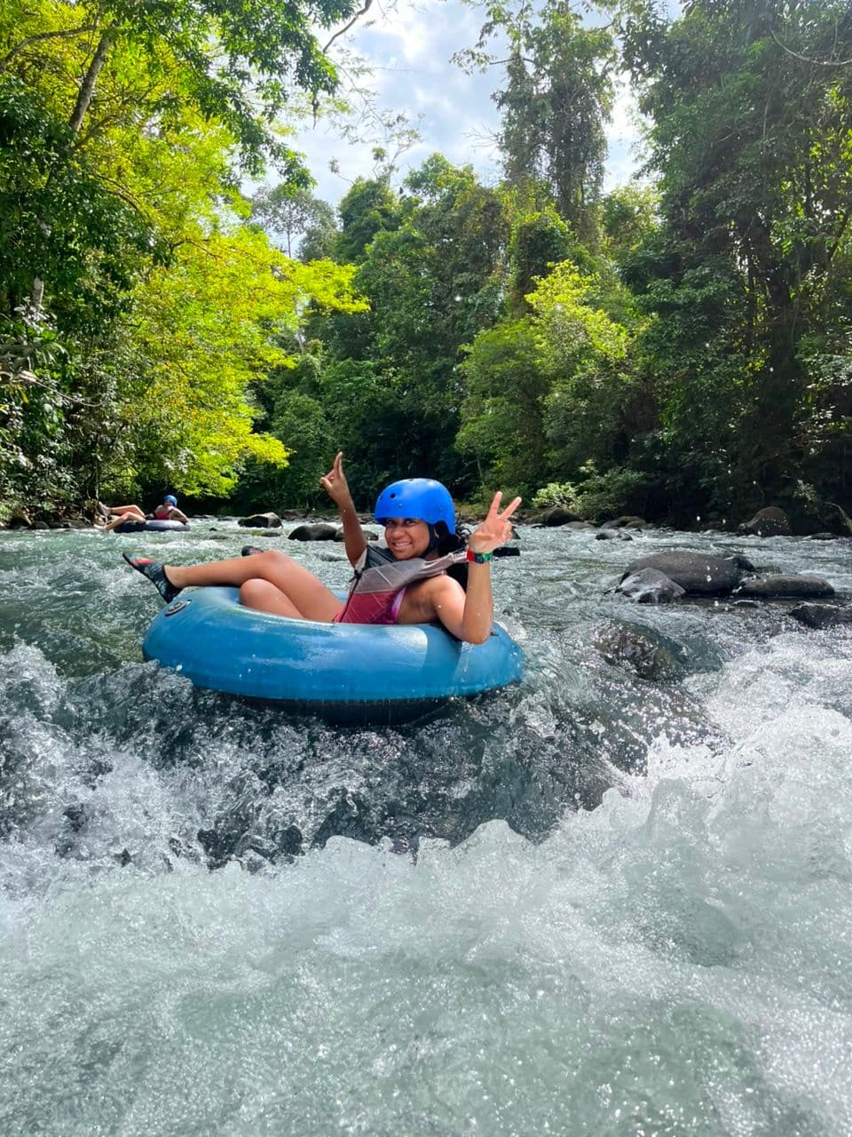 Tourist tubing on the turquoise waters of Rio Celeste, Costa Rica — guided river adventure near Tenorio Volcano National Park